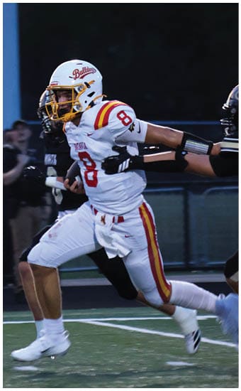 Two football players wearing blue and white uniforms. Description generated by AI