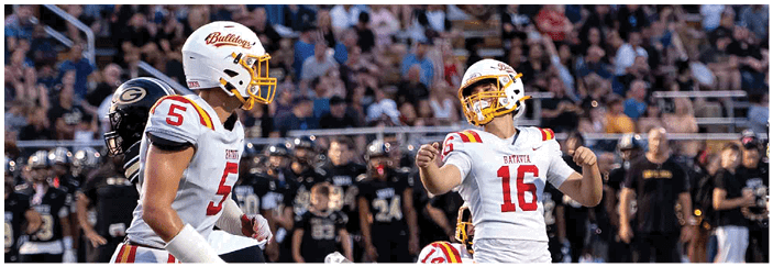 A football game is taking place on a field with players wearing blue and white uniforms. Description generated by AI