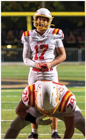 Two football players wearing blue and white uniforms. Description generated by AI