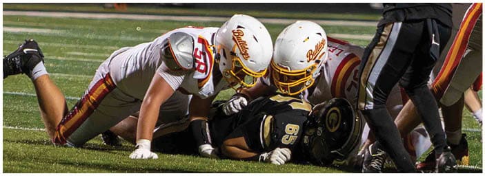 A group of football players on a field. Description generated by AI