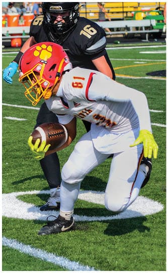 A football player catching a ball. Description generated by AI