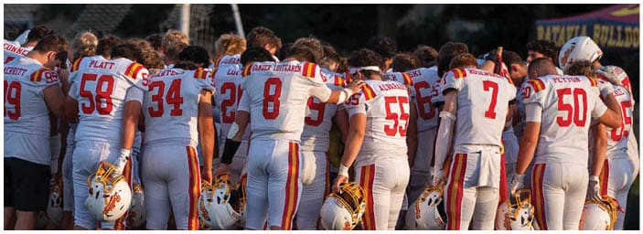 A group of football players on a field. Description generated by AI