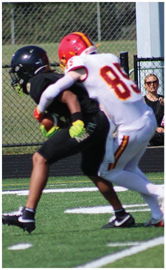 A football player catching a ball. Description generated by AI