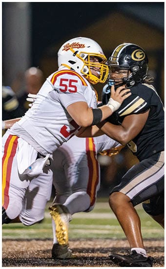 Two football players wearing blue and white uniforms. Description generated by AI