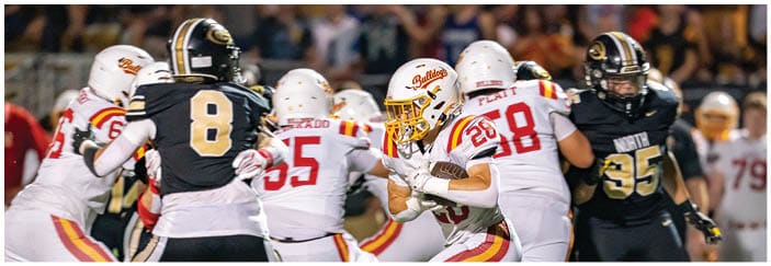 A football game is taking place on a field with players wearing blue and white uniforms. Description generated by AI