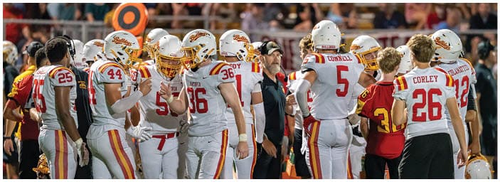 A group of football players on a field. Description generated by AI