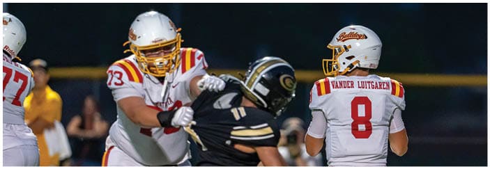 A football game is taking place on a field with players wearing blue and white uniforms. Description generated by AI