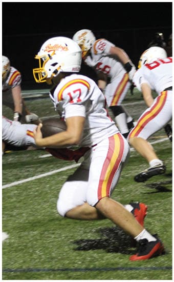 Two football players wearing blue and white uniforms. Description generated by AI
