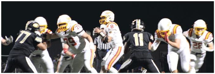 A football game is taking place on a field with players wearing blue and white uniforms. Description generated by AI
