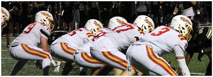 A group of football players on a field. Description generated by AI