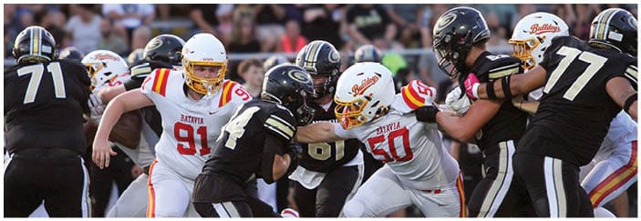 A football game is taking place on a field with players wearing blue and white uniforms. Description generated by AI