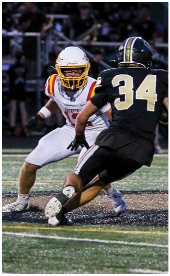 Two football players wearing blue and white uniforms. Description generated by AI