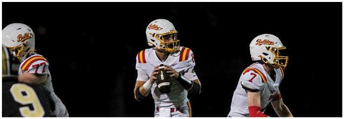 A football game is taking place on a field with players wearing blue and white uniforms. Description generated by AI