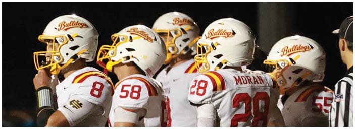 A group of football players on a field. Description generated by AI