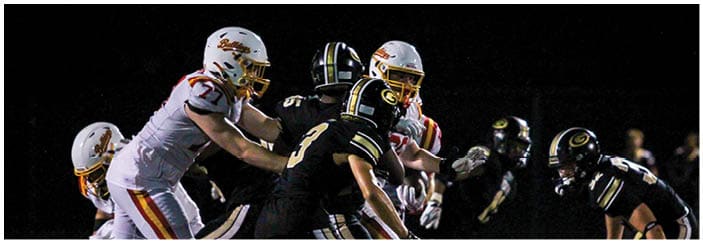 A football game is taking place on a field with players wearing blue and white uniforms. Description generated by AI
