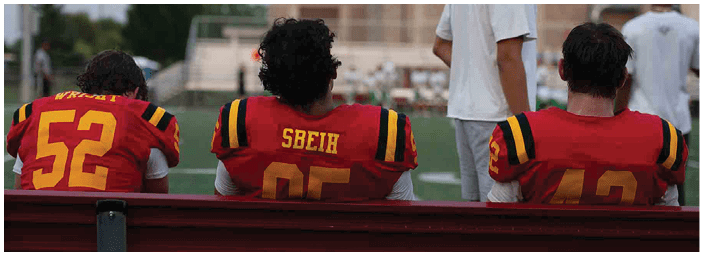 A group of football players on a field. Description generated by AI