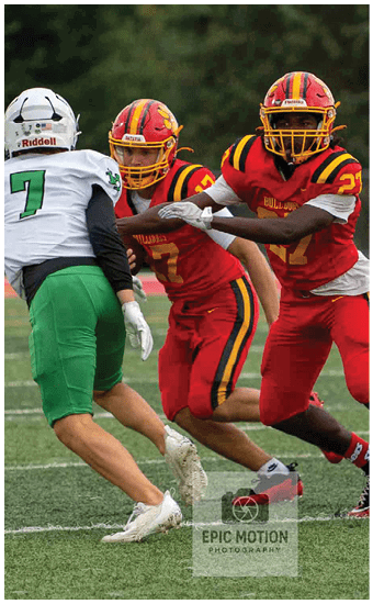 Two football players wearing blue and white uniforms. Description generated by AI