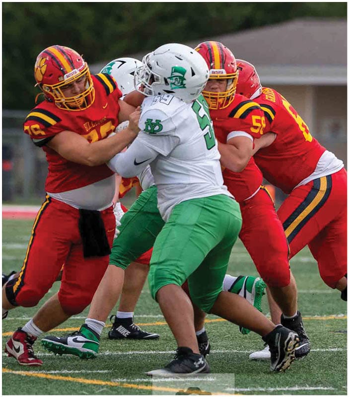 A group of football players on a field. Description generated by AI