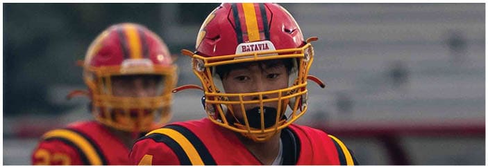A football game is taking place on a field with players wearing blue and white uniforms. Description generated by AI