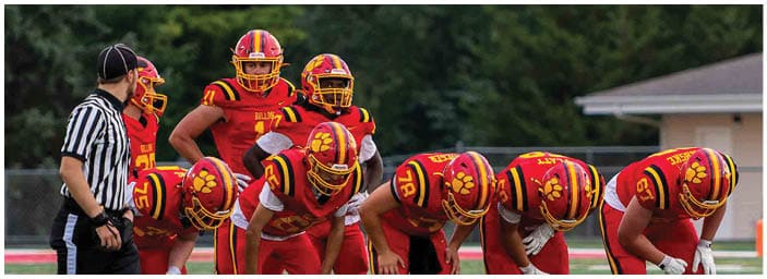 A group of football players on a field. Description generated by AI