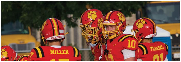 A football game is taking place on a field with players wearing blue and white uniforms. Description generated by AI