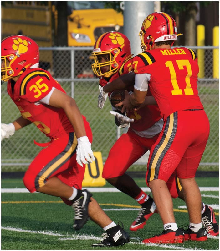 A group of football players on a field. Description generated by AI