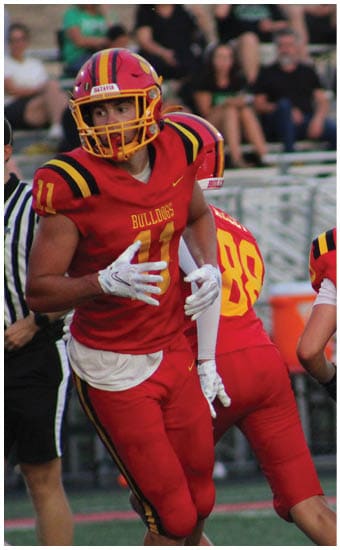 Two football players wearing blue and white uniforms. Description generated by AI