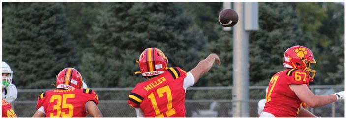 A football game is taking place on a field with players wearing blue and white uniforms. Description generated by AI