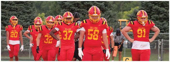 A group of football players on a field. Description generated by AI