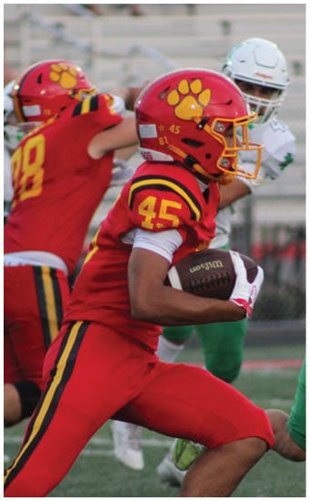 Two football players wearing blue and white uniforms. Description generated by AI