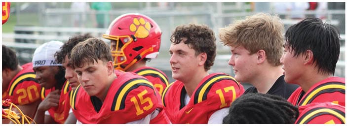 A group of football players on a field. Description generated by AI