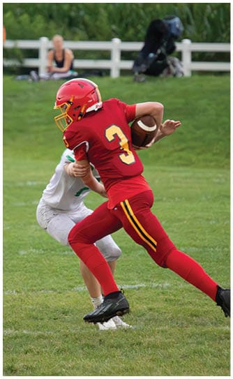 A football player catching a ball. Description generated by AI