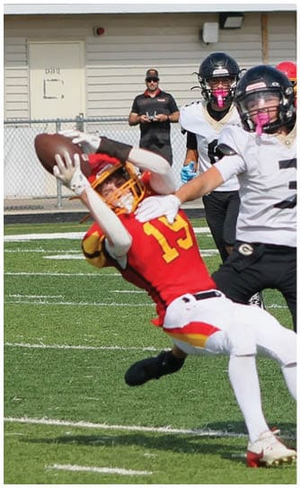 A football player catching a ball. Description generated by AI