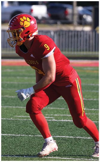 A football player catching a ball. Description generated by AI