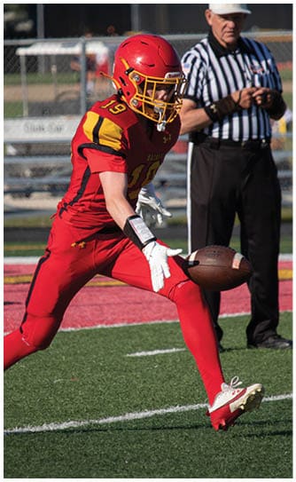 A football player catching a ball. Description generated by AI