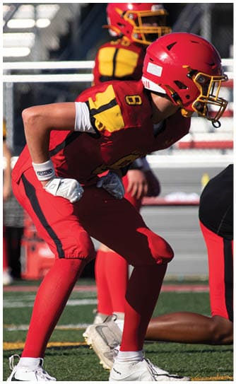 A football player catching a ball. Description generated by AI