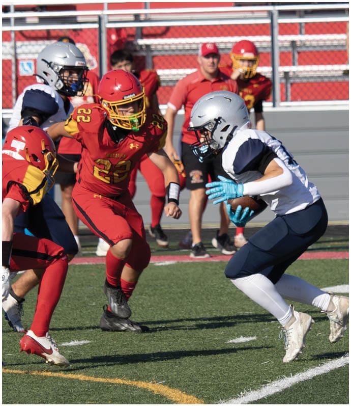 Three football players in blue and white uniforms running on a field. Description generated by AI