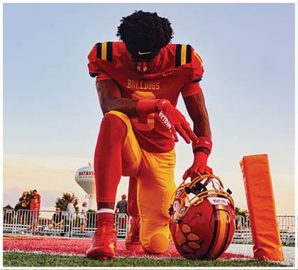A football player running on the field. Description generated by AI