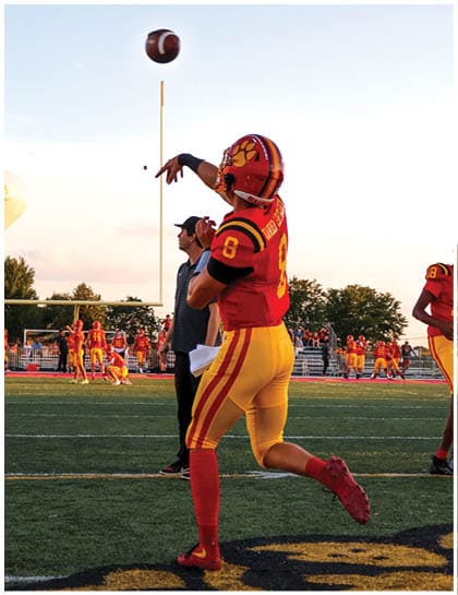 A football player wearing a blue and red jersey. Description generated by AI