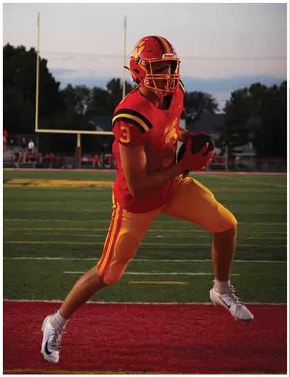 A football player wearing a blue and red jersey. Description generated by AI