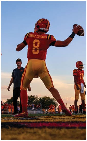 Two football players wearing blue and white uniforms. Description generated by AI