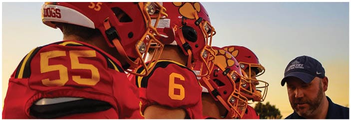 A football game is taking place on a field with players wearing blue and white uniforms. Description generated by AI