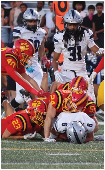 Two football players wearing blue and white uniforms. Description generated by AI