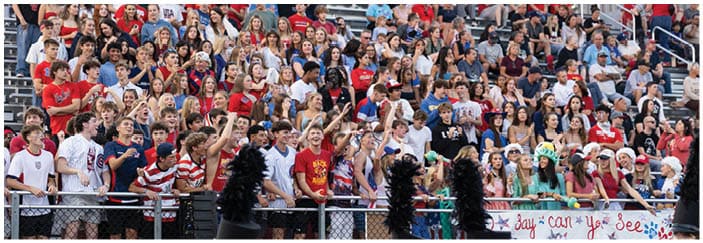 A football game is taking place on a field with players wearing blue and white uniforms. Description generated by AI