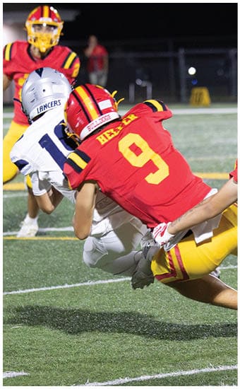 Two football players wearing blue and white uniforms. Description generated by AI