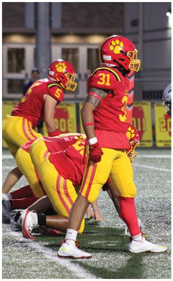 Two football players wearing blue and white uniforms. Description generated by AI