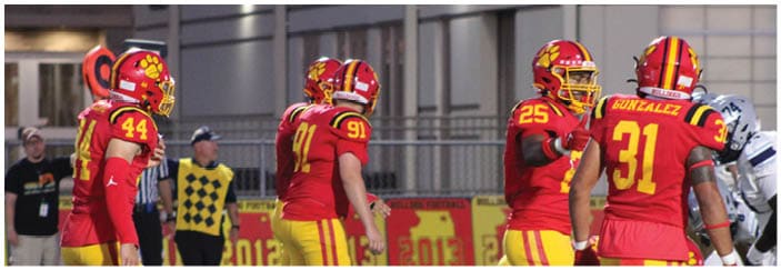 A football game is taking place on a field with players wearing blue and white uniforms. Description generated by AI