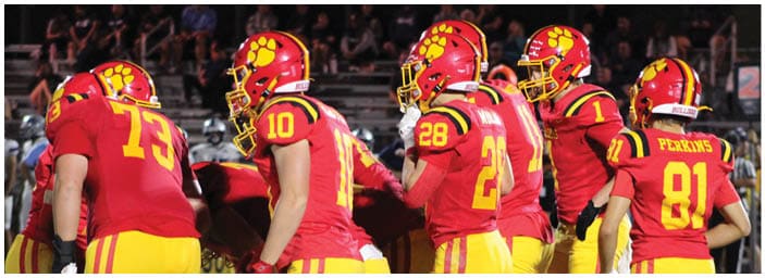 A group of football players on a field. Description generated by AI