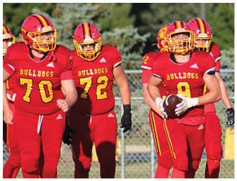 A group of football players on a field. Description generated by AI