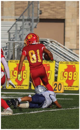 A football player catching a ball. Description generated by AI